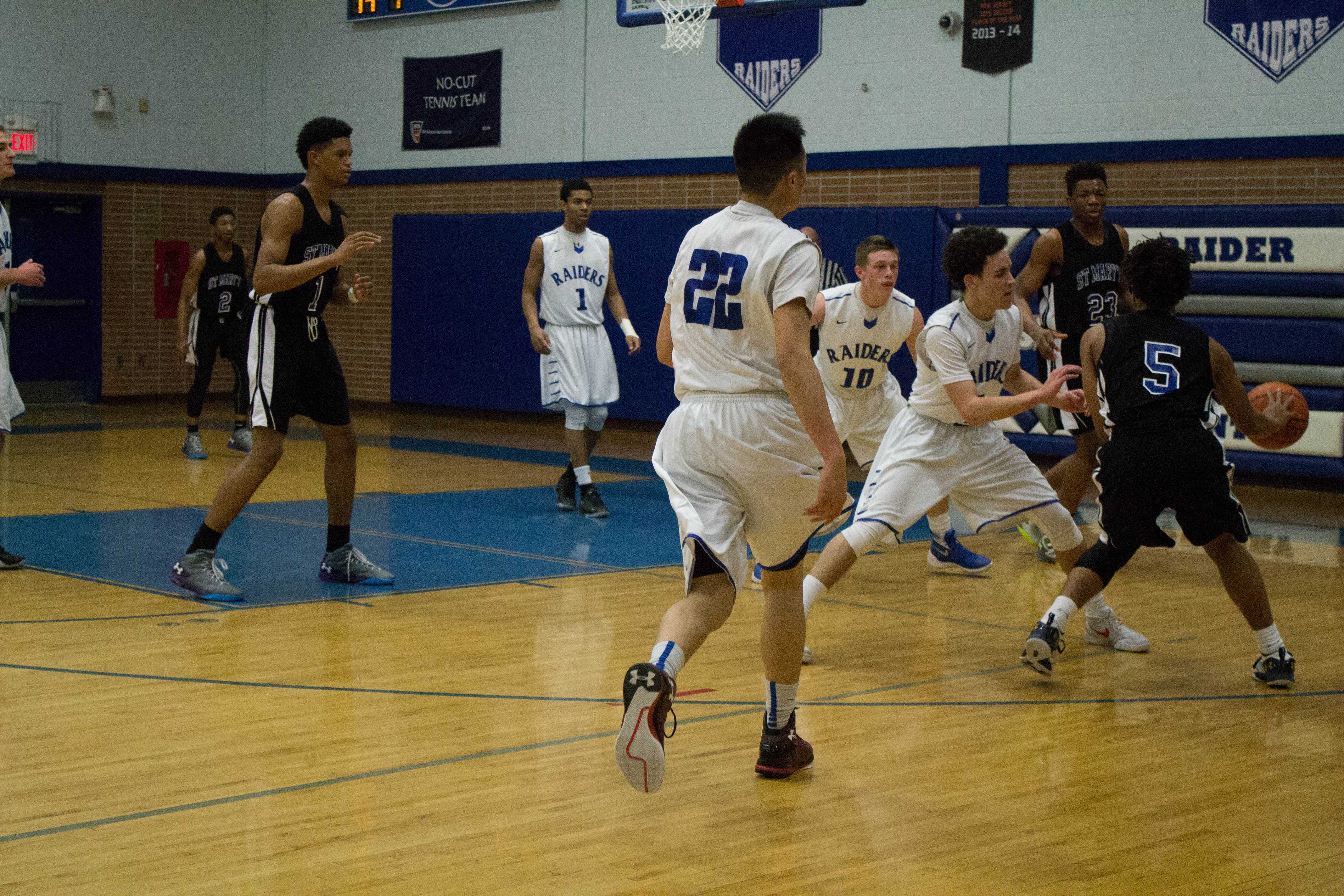 Shooting guard, Theodore Willmott attempts to steal the ball away from St. Mary. 