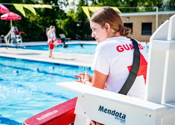 A lifeguard watches over a pool. Increases in lifeguarding positions during the summer provide opportunities for high school students to get summer jobs.
