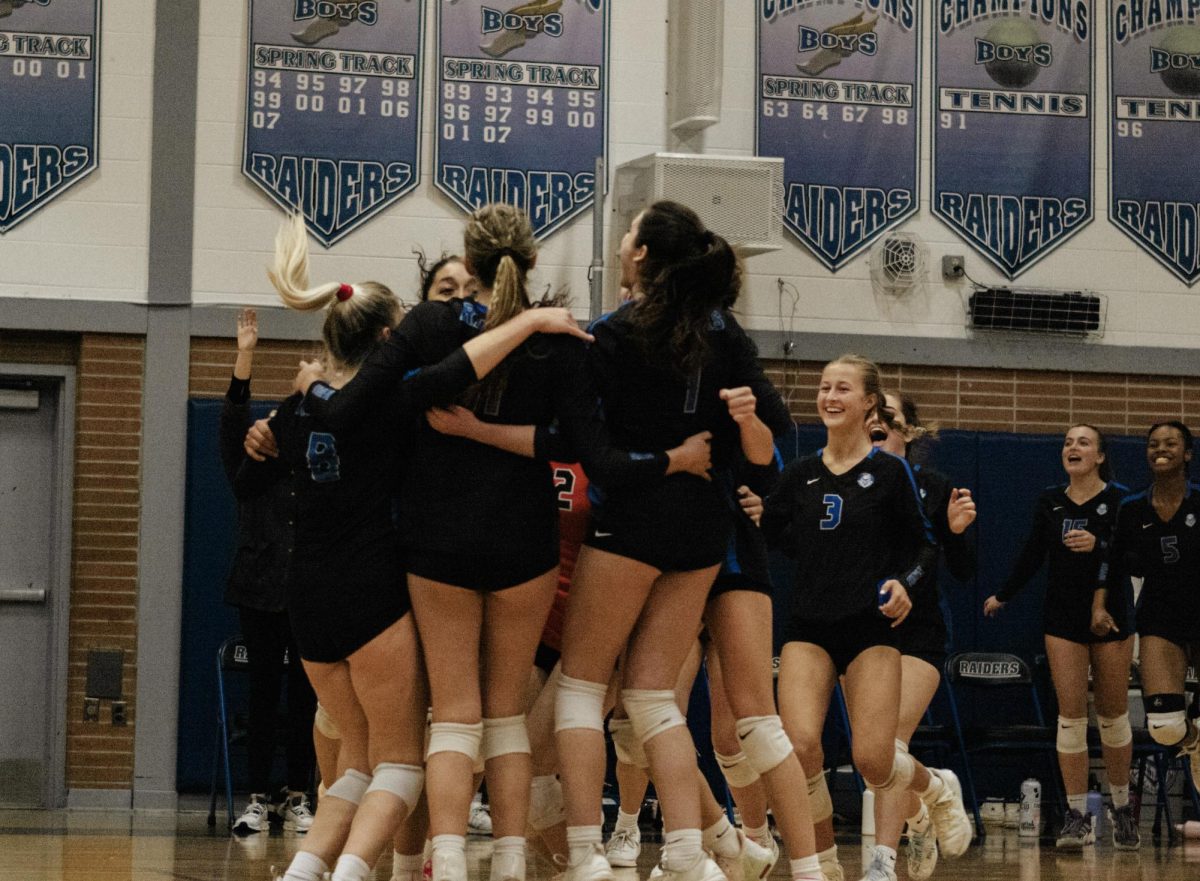 The Lady Raiders celebrate after defeating the Chatham Cougars (25-14, 25-19). The team advanced to the sectional championship. 