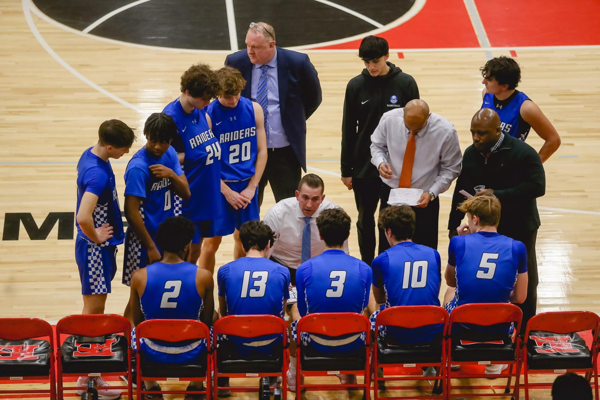 Players huddle around coach Steven Siracusa during a timeout against the Elizabeth Minutemen on Feb. 12. The SPF Boys Basketball team finished the 22-23 season with a record of 16-10 and made it to the sectional quarterfinals.