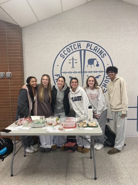Members of Holding Hands Club pose behind their bake sale. Holding Hands Club is a new club at SPFHS created to welcome freshmen to high school.