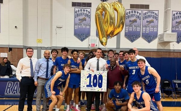 The SPFHS Boys Basketball team celebrates with Coach Steven Siracusa after his 100 career victory. The Raiders defeated the Cranford Cougars 53-38 on Thursday Jan. 11 at Scotch Plains-Fanwood High School.