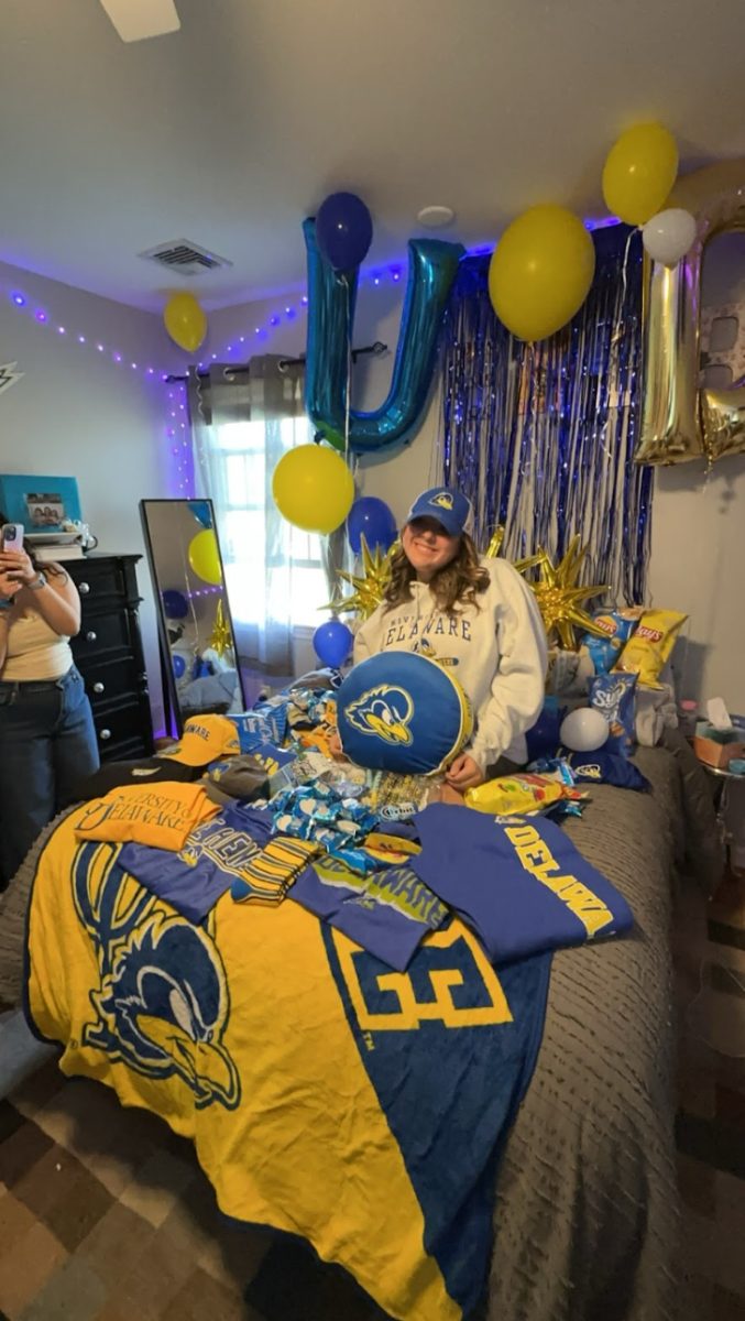 Emersyn Teicher sits on her bed covered by University of Delaware apparel. She was very surprised when she walked into her room. 