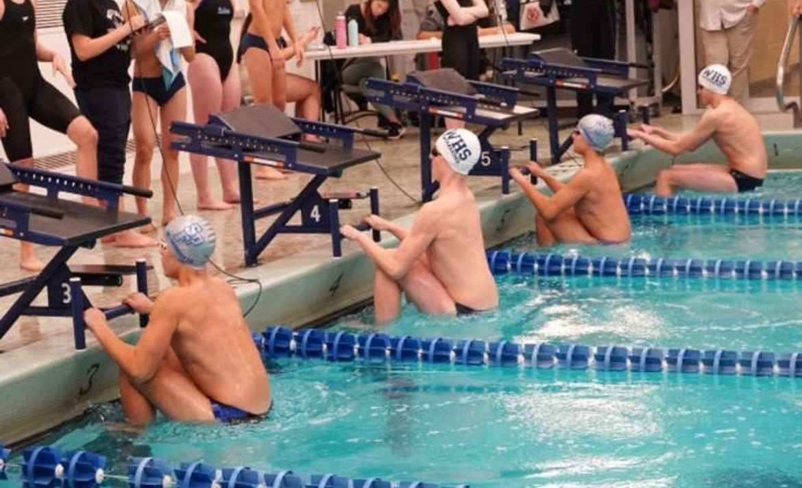 Swimmers of the Scotch Plains-Fanwood boys team hold on to starting blocks. The boys finished 6-5 last season. 