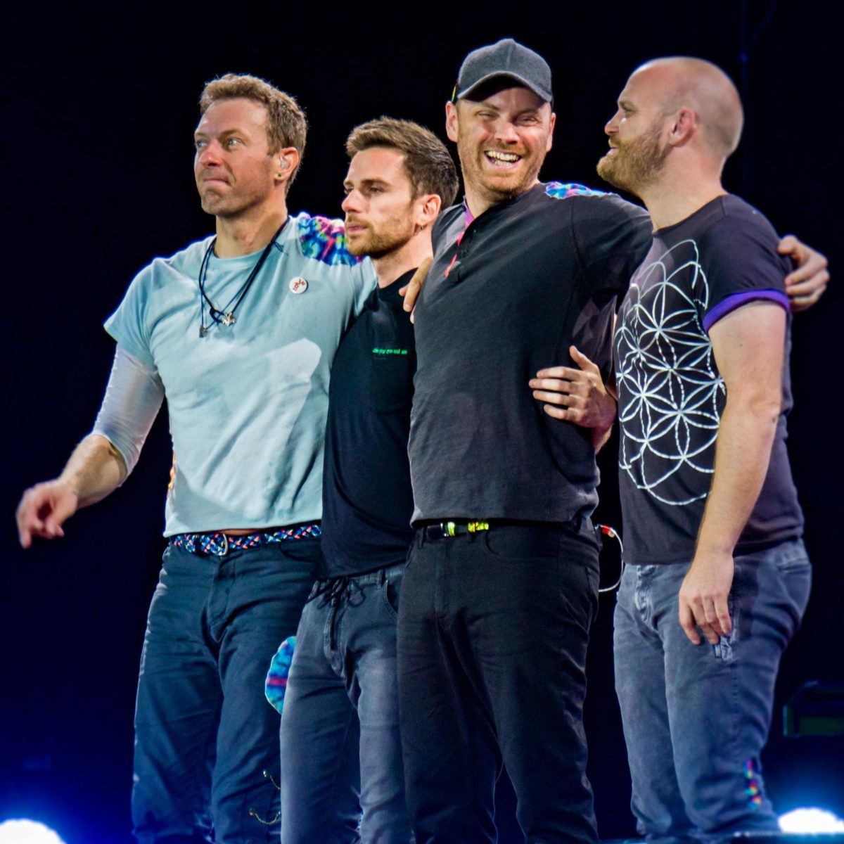 Coldplay members embrace on stage during a performance. This photo was taken during their 2017 performance at the Rose Bowl. 