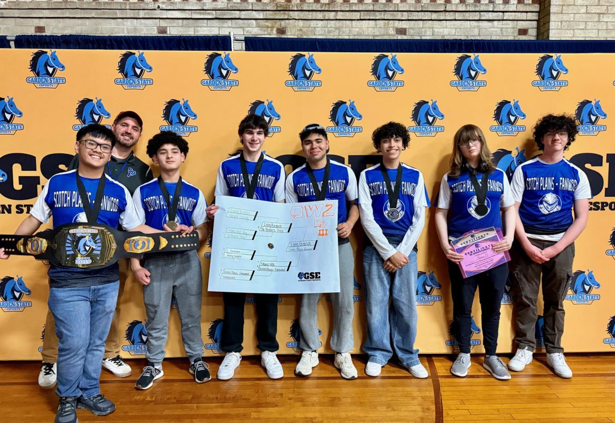 The Raider Esports team poses with their championship belt and bracket at the Garden State Esports Championships. The Raiders defeated Long Branch High School on March 1. 2025 to claim their third straight Overwatch II state title. 