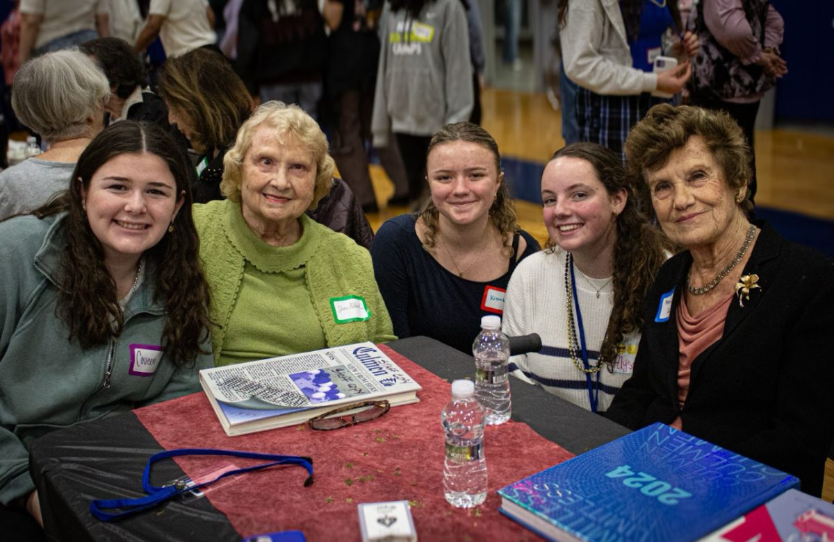 Juniors Collen Gillen, Kiersten O’Donnell, senior Alyssa Verducci and attendees posing for a photo after flipping through old yearbooks. There was downtime incorporated throughout the day for moments like these.