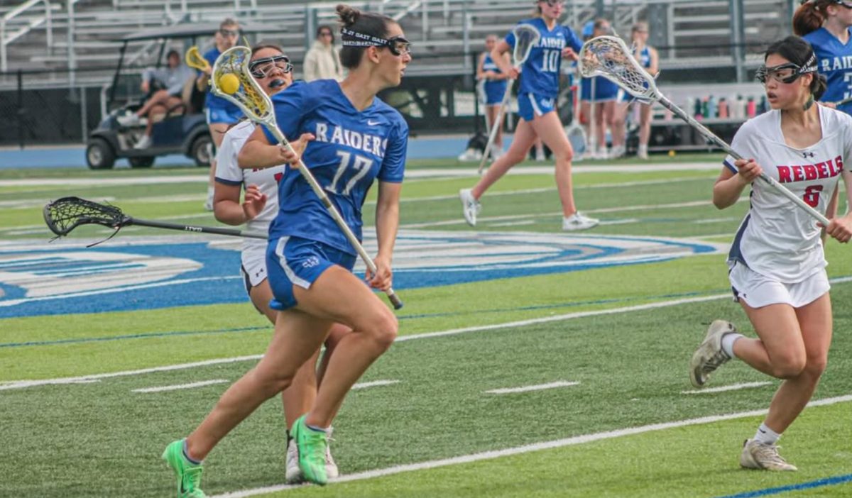 Senior Juliana Doran maintains possession for the Raiders as opposing players approach her. Doran scored eight goals in a 20-10 rout against Saddle River Day on April 22.  