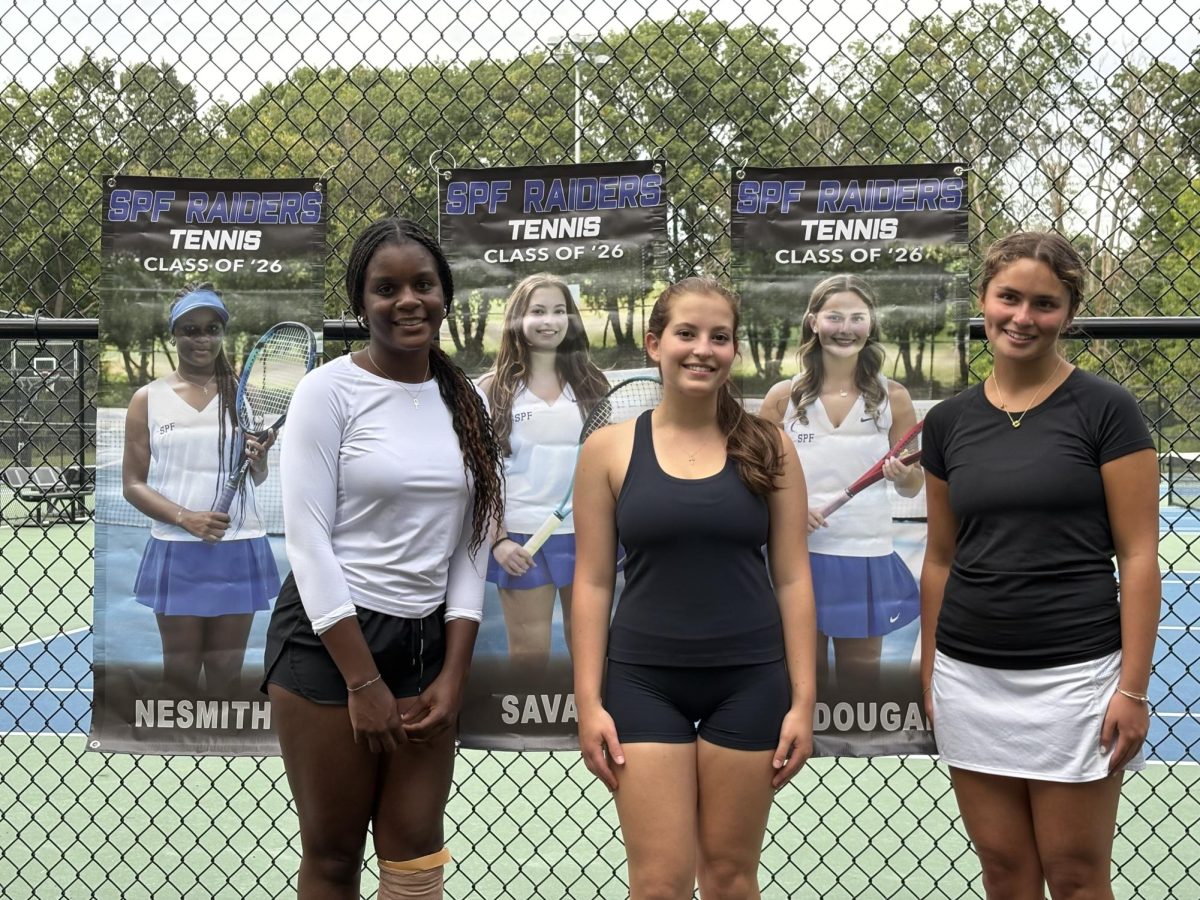 Seniors on the girls tennis team pose by their banners on senior day. The girls tennis team has gotten off to a hot start on the season with an 8-1 record.