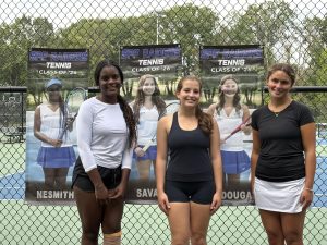 Seniors on the girls tennis team pose by their banners on senior day. The girls tennis team has gotten off to a hot start on the season with an 8-1 record.