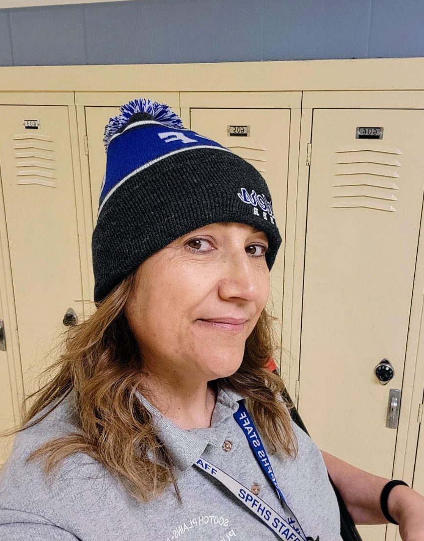 Our head custodian poses in the school hallways, showing her school spirit wearing Raider gear. After many years of hard work, she is retiring. 
