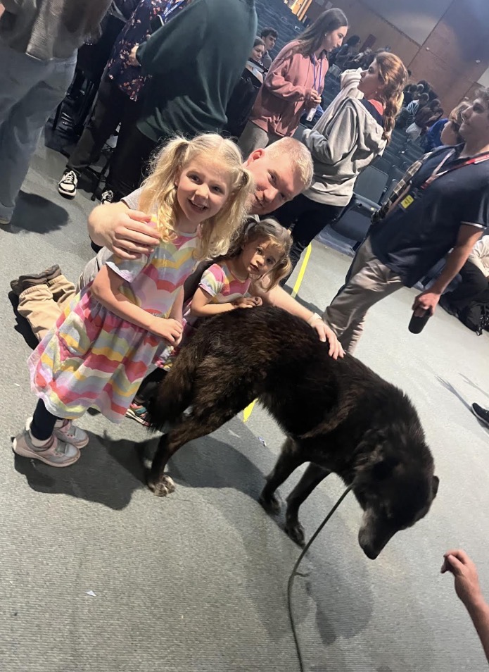 Michael Hergenhan and his two daughters pose together while petting a wolf dog. This was one of their favorite experiences of the day. 